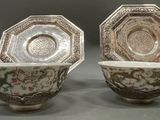 two cups and saucers are sitting side by side on a table