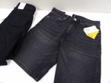 two pairs of black jeans sitting on top of a white table