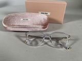 une paire de lunettes transparentes posée sur une table à côté d'un étui rose