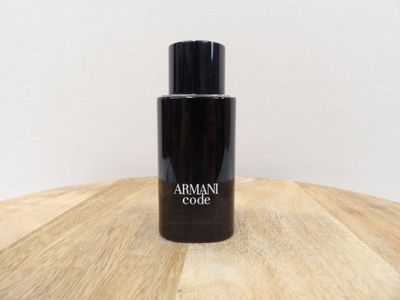 une photo d'un flacon de parfum posé sur une table en bois