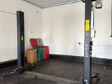 an image of a garage with a lift in the middle of the room
