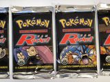 four packs of pokemon trading cards are lined up on a table