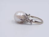 a white pearl and diamond ring on a white background