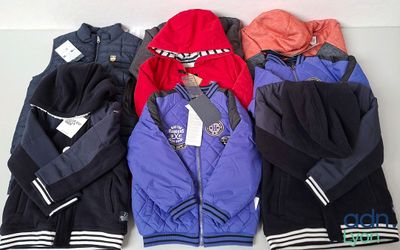 Plusieurs vestes sont alignées sur une surface blanche