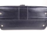 black leather purse with metal studs sitting on a white surface