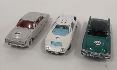 trois voitures jouets assises l'une à côté de l'autre sur une table