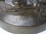 a bronze statue of a woman with a flower in her hair