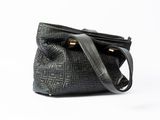 the small black bag is sitting on a white surface