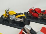 three different models of motorcycles on display on a table