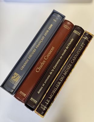 trois livres sont empilés sur une table