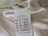 givenchy label on a bed sheet with a white comforter in the background