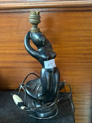 a statue of a woman holding a lamp on a table
