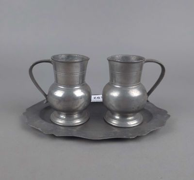 une paire de tasses et soucoupes en métal argenté, présentées sur un plateau en argent
