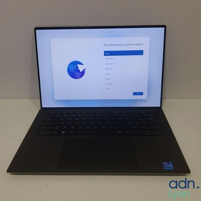 un ordinateur portable ouvert posé sur une table blanche