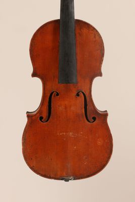 an old violin hanging from a string on a wall
