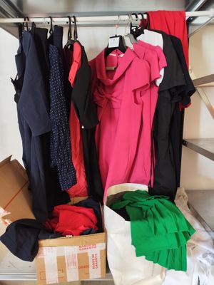 beaucoup de vêtements suspendus à une étagère dans une pièce