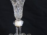 a close up of a three tiered glass cake plate on a black background
