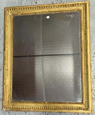 un miroir à cadre doré accroché au mur, avec une fenêtre en arrière-plan
