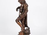 a bronze statue of a man holding a bird on a pedestal