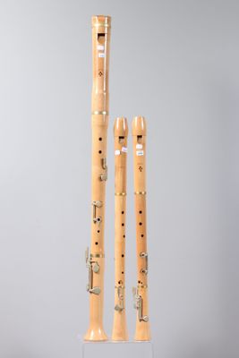 two wooden flutes are sitting on a stand on a gray surface