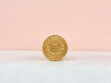 a gold coin sitting on top of a white surface