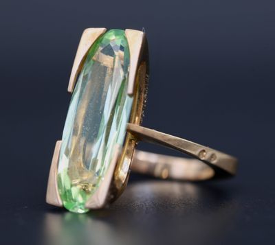 Gros plan sur une bague contenant une pierre verte
