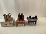 three pairs of women ' s shoes sitting on top of boxes next to each other