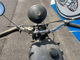 une moto garée dans la rue, le guidon rabattu