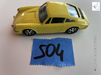 une petite voiture jaune posée à côté d'une feuille de papier bleue