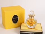 perfume bottle in a yellow box next to a yellow box with a black lid