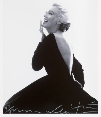 a black and white photo of a woman in a black dress
