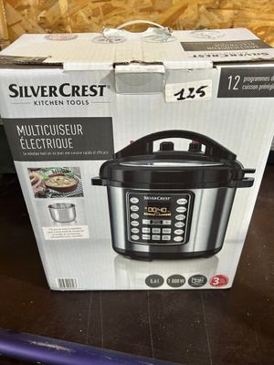 the box of a multi - use electric pressure cooker sits on a table