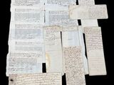 several old papers are stacked on top of each other on a black surface