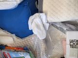a pile of mattresses and other items on the floor