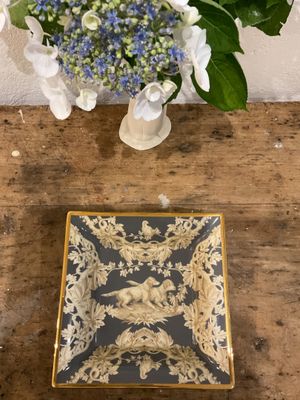 un vase de fleurs posé sur une table à côté d'une assiette