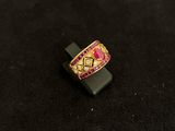 pink and gold ring on a black stand on a black surface