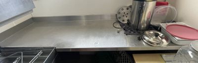 stainless steel counter top in a commercial kitchen with pots and pans on it