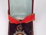 an image of a medal in a case with a red ribbon