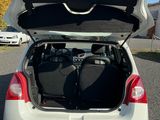 the back of a white car with its trunk open in a parking lot