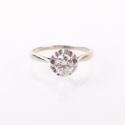 gros plan d'une bague en diamant sur une surface blanche