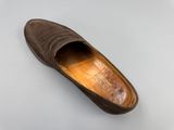 des chaussons marron posés sur une surface blanche, sur fond blanc