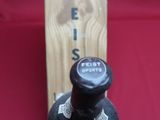 une bouteille de vin posée à côté d'une boîte