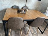 a wooden table with two chairs and a clock on it