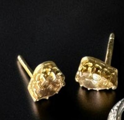 pair of gold and diamond earrings on a black surface
