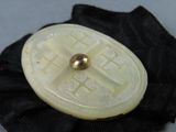 a picture of a brooch with a gold ball on it