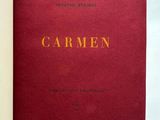 an open book with a red cover sitting on top of a white table
