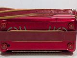 a red suitcase with a strap on it sitting on a table