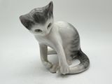 a figurine of a cat sitting on a white surface