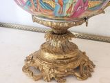 a decorative bowl on a gold stand with a bird on it