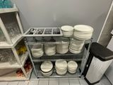 de nombreuses assiettes et bols empilés sur une étagère dans la cuisine